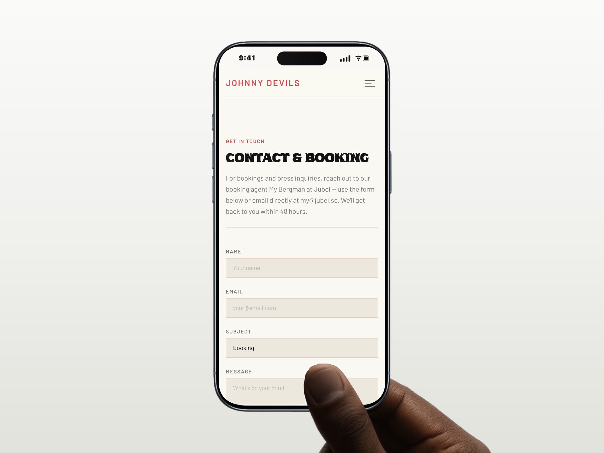 A hand holding an iPhone with the contact and booking page on johnnydevils.com