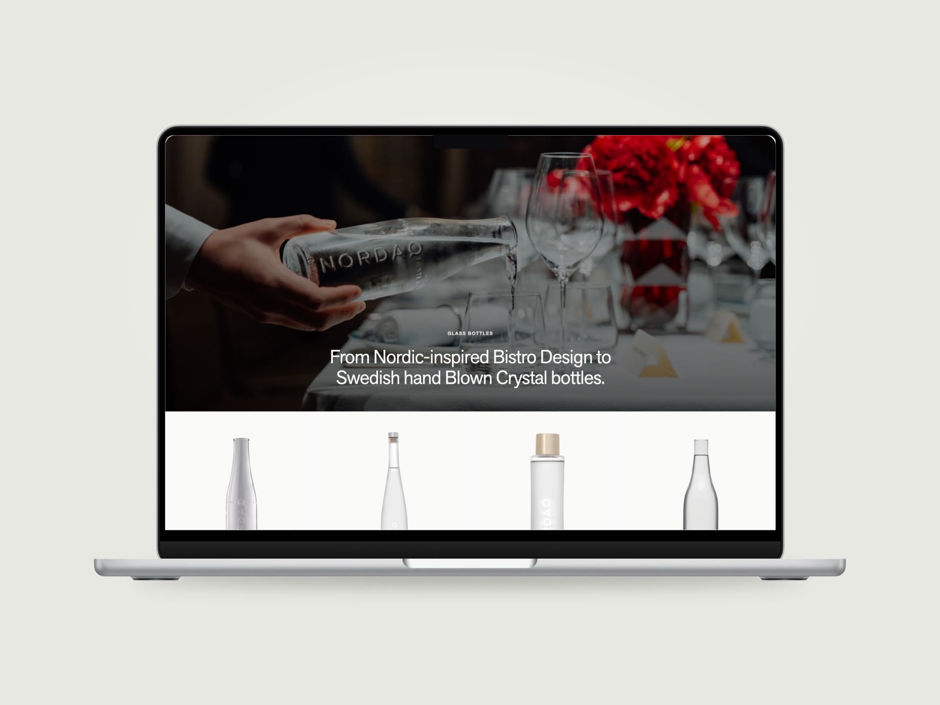 The Nordaq Glass Bottles page on a MacBook, a waiter pouring a crystal bottle at a set table, four bottle styles below