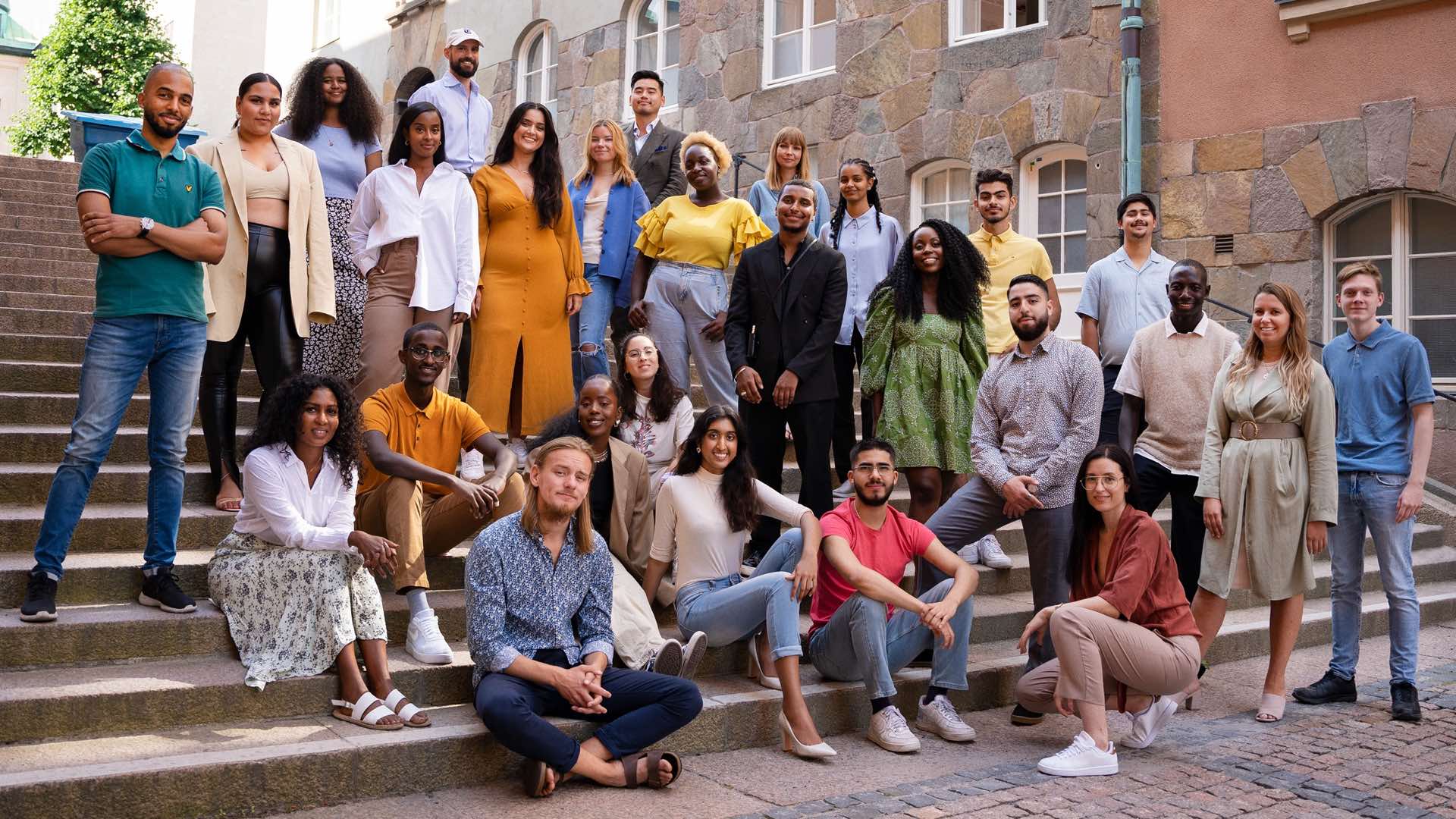 The :PART crew and its youth consultants on stone steps in Stockholm, about thirty people in summer clothes