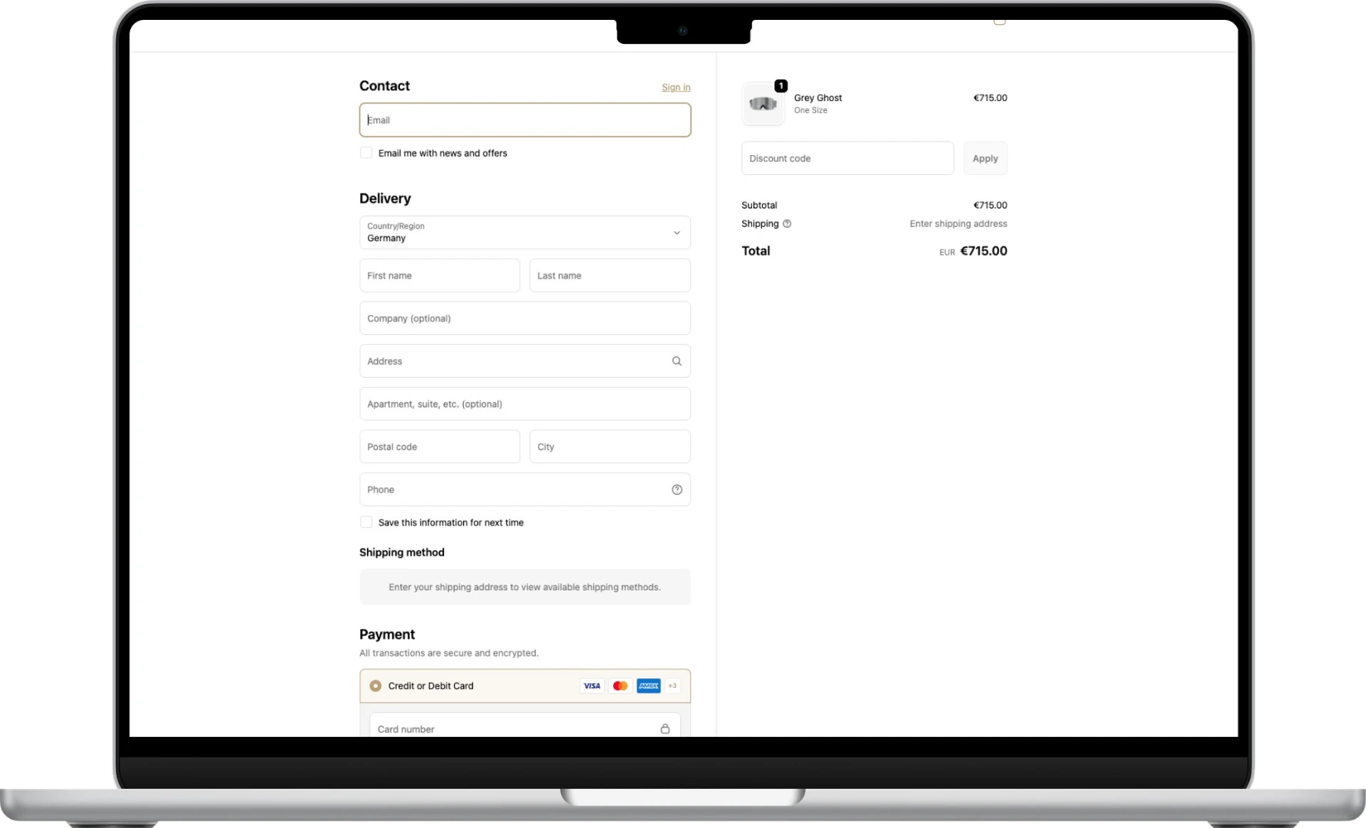 MacBook showing the YNIQ checkout, a single pair of goggles called Grey Ghost in the order summary